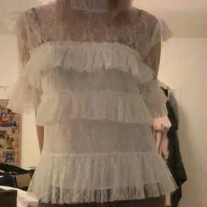 By malina blus - Säljer min by malina Rachel blus. Den är i jätte fint skick och har inga defekter. En romantisk vit blus i spets med flera lager volanger både framtill och på ärmarna. Blusen är genomskinlig och har korta ärmar. Perfekt för dig som gillar en feminin och trendig stil! Hör av er vid frågor eller intresse! Postar inom 24h💕💕💕den passar s/m🥰