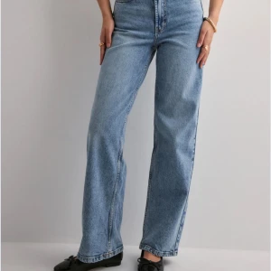 Blå wide leg jeans från Nelly (för korta tjejer) - Säljer ett par ljusblå jeans från Nelly med hög midja och raka, vida ben. Dessa jeans är lite för långa på mig (158), men med skor nuddar de inte ens golvet så tjejer som är 165-160 är dessa perfekta för en avslappnad och trendig look 👀 
