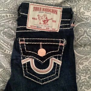 SÄLLSYNTA Rosa true religion jeans!  - Säljer dessa super fina rosa true religion jeans då de blivit någorlunda för små  för mig. Är i bootcut modell och har ett ganska stretchigt material. Har använts bara några gånger och därför i superbra skick! Lite dåliga bilder men kan skickas mer om det önskas💕Storlek 23W/xxs/xs (minsta storlek) Nypris-ca 2500 kr 