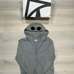 Grå hoodie med goggles från C.P. Company - Tja! Säljer nu min C.P . Company tröja eftersom för liten. Köpt på NK och är mycket fint skick! Hör av er vid minsta fråga!