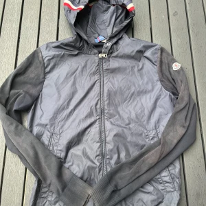 Moncler cardigan - Tjena, säljer nu denna riktigt snygga och populära Moncler cardiganen, den är i använt skick, solblekt på vissa ställen, saknar snörena, finns ett pinehole och att den är aningen smutsig, hör av er vid frågor och funderingar🙌🤝