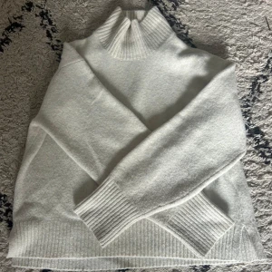 Cremevit stickad polotröja - Superfin cremevit stickad polotröja från uniqlo. Materialet känns mjukt och värmande, och den höga kragen ger extra komfort. Storlek XS men är skulle säga att den passar både S och M. Säljer på grund av att den inte kommer till användning💕