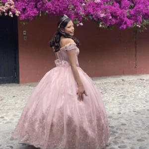 Rosa prinsessklänning med spetsdetaljer - Drömmig långklänning i ljusrosa med offshoulder och voluminös kjol. Klänningen har vackra spetsdetaljer och blommor, samt markerad midja med rosett. Perfekt för bal eller quinceañera. Klänningen går och anpassa för storlek, och storleken på kjolens volym. Hyr klänningen. Skriv privat för mer information 