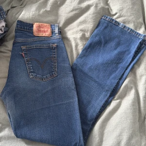 Levi's 586  blå jeans bootcut - Klassiska blå Levi's  jeans med bootcut-snitt. Snyggt mellanblå tvätt, femficksmodell och ikonisk läderpatch bak i midjan. Tidlös modell med orange sömmar och rakt ben, perfekt för dig som gillar retrovibbar.