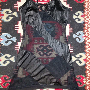 Svart meshklänning med satinpaneler - Snygg svart kortklänning med transparent mesh och blanka satinpaneler i coola diagonala mönster💌