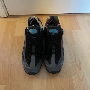 Nike X Corteiz - Snygga Nike sneakers i svart och grått med coola camo-detaljer i fodret och turkosa loggor. Skorna har snörning, meshpaneler och en chunky sula som ger en sportig vibe. Perfekta för dig som vill sticka ut med unika detaljer och streetstyle. Nästan nya anväds ett fåtal gånger. Har inte används på länge däför jag säljer dom. Kan diskutera pris vid snabb afärr