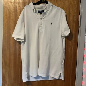 Vit kortärmad skjorta Ralph Lauren - Vit kortärmad skjorta från Ralph Lauren med klassisk krage och knappar framtill. Skjortan har broderad logga på bröstet och är tillverkad i ett mjukt bomullstyg. Perfekt för en clean och stilren look.