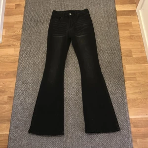 Svarta bootcut jeans från SHEIN i storlek S - Säljer ett par helt oanvända svarta jeans från SHEIN i bootcut-modell med klassisk femficksdesign. Jeansen har hög midja och är tillverkade i ett stretchigt denimtyg som sitter snyggt över höfterna och släpper ut över benen. Perfekta för dig som gillar en retroinspirerad look.