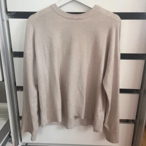 Beige stickad tröja från BikBok - Säljer en beige stickad tröja från BikBok i storlek S. Tröjan har en rund halsringning, långa ärmar och ribbade muddar vid hals, ärmslut och nederkant. Perfekt för dig som gillar en enkel och clean look med lite loose passform.