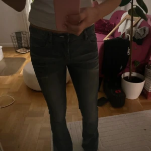 Blå bootcut jeans från Acne - Snygga blå jeans från Acne med klassisk bootcut-modell och normal passform. Jeansen har fem fickor, dragkedja och knapp framtill samt Acne-logga bak i midjan. Tillverkade i mjukt denimtyg som ger en avslappnad vibe.