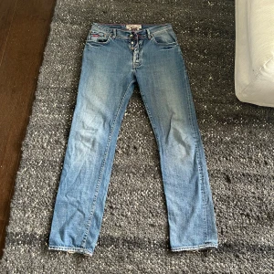Jacob Cohen ljusblå jeans med röd söm - Snygga ljusblå jeans från Jacob Cohen med handgjorda detaljer och röd kontrastsöm. Klassisk femficksmodell med broderad logga på fickan och patch i mocka baktill. Jeansen har rak passform och är tillverkade av japanskt utvalt bomullstyg.