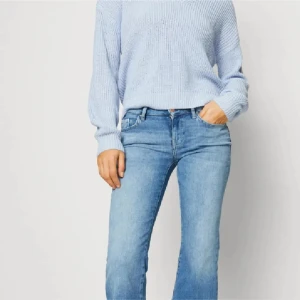 Blå bootcut jeans från ONLY - Snygga ljusblå bootcut jeans från ONLY med klassisk femficksdesign och dragkedja. Jeansen har hög midja och är tillverkade i mjukt denimtyg med lätt tvättad look. Perfekt passform och cool stil för dig som gillar retrovibbar.