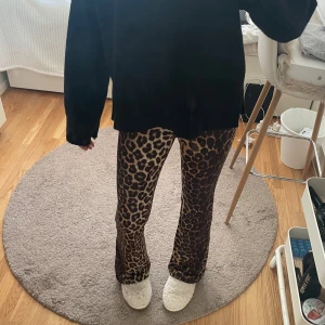 Leopardmönstrade bootcut byxor - Säljer ett par snygga leopardmönstrade bootcut byxor med bruna och svarta toner. De har en skön passform och skönt material. Köpta second hand och saknar lapp i bak.