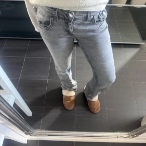 Grå bootcut jeans med fickor - Säljer ett par grå lågmidjade jeans med bootcut passform och snygga fickor från Gina Young! säljer pga ingen användning. Använd gärna ”KÖP NU” nypriset ligger på 360kr