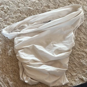 Vit topp från Zara - Så snygg, trendig o slutsåld topp från zara. Tröjan ser lite sneskuren ut vid bröstet vilket är såå snyggt! Har en liten brun fläck vid bröstkorgen, men syns inte jättteeeemycket.