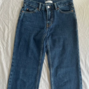 Blå low straight Jeans Gina Tricot - Säljer ett par svarta jeans från Gina Tricot, modellen Perfect Jeans low straight petite. De har en rak passform, klassisk femficksdesign och dragkedja i gylfen. Jeansen är tillverkade i bomull. Längden är av petit serien så innerbenslängden ca 76cm. Storlek 32 och ca 62 cm i midjan. Är i nyskick och endast använda fåtal gången och hela utan något slitage samt rena. (nypris 500kr) Pris kan diskuteras