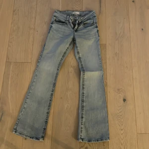 Bootcut ljusblå jeans från Perfect Jeans - Säljer ett par ljusblå bootcut jeans från Perfect Jeans i storlek 34. De har klassisk femficksdesign, snygga slitningar och kontrastsömmar. Jeansen har låg midja och är tillverkade i mjukt denim-material som sitter skönt hela dagen.