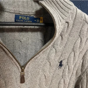 Ralph lauren kabelknit half zip  - Säljer en grå stickad tröja från Polo Ralph Lauren med kabelstickat mönster och half zip-dragkedja. Självklart ÄKTA✅! Använd ett fåtal gånger då den inte satt på mig som jag egentligen tänkte. Köpt för 2500 kr. Qr kod kan skickas vid förfrågan