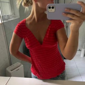 Röd randig v-ringad topp - Säljer denna super snygga topp, storlek M men skulle säga att den sitter mer som en S.