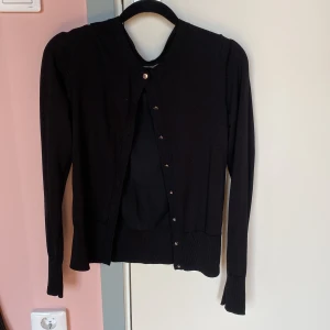 Svart ribbad kofta med knappar från Lindex  - Säljer denna söta kofta från Lindex. Nästan aldrig använd. Nypris 350