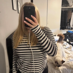 Svartvit randig långärmad tröja - Säljer en svartvit långärmad tröja med klassiskt horisontellt randigt mönster. Tröjan har rund hals och är i mjuk bomull, perfekt för chill dagar. Passformen är normal och den är enkel att matcha med jeans eller svarta byxor.