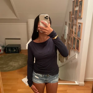 Mörkblå långärmad basic tröja - En enkel och stilren mörkblå långärmad tröja med rund hals. Modellen är slim och sitter snyggt mot kroppen. Perfekt att matcha med jeans eller shorts. Materialet känns mjukt och lätt, troligen bomull eller polyester. Passar dig som gillar minimalistisk stil. Oanvänd 