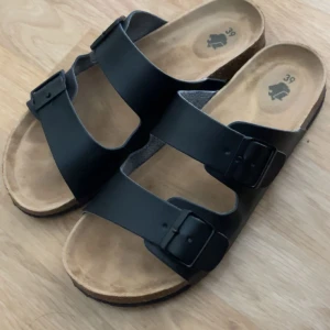 Svarta sandaler med dubbla spännen - Säljer mina tofflor som är använda endast en gång pga att de är lite för små, de är i storlek 39🩷