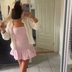 Ljusrosa kort klänning med volang - Superfin ljusrosa klänning med volang nertill och axelbandslös design. Klänningen är kort och har en slim passform som framhäver figuren. Perfekt till allt!