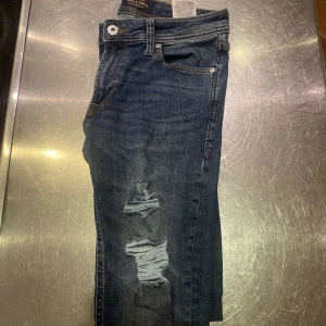 Mörkblå jeans från Jack & Jones - Säljer nu ett par mörkblå slim fit jeans från jack & Jones. De har riktigt sköna slitningar och är tillverkade med flexibelt material så man får skönare pass form. Pris kan diskuteras vid snabb affär , hör av er vid minsta fundering