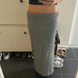 Grå ribbad långkjol från 157 - Säljer en mysig grå stickad långkjol från 157 i storlek XS. Kjolen har ribbad struktur och är figurnära med hög midja. Perfekt för dig som gillar chill och stilren vibe under höst och vinter. Fråga gärna om fler bilder eller info!(JAG HAR SYT IGEN DEN ÖPPNINGEN VID BENET MAN KAN INTE SE FRÅN LÅNGT HÅLL MAN MÅSTE KÄNNA DEN)