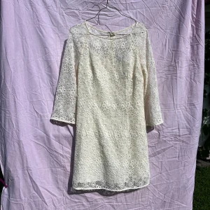 Vit spetsklänning från & Other Stories - Superfin vit spetsklänning från & Other Stories Paris Atelier i storlek 40. Klänningen har blommigt spetsmönster, trekvartsärm och rund hals. Den är fodrad och har dragkedja i ryggen. Materialet är mestadels bomull och polyester. Perfekt för sommarens alla tillfällen!