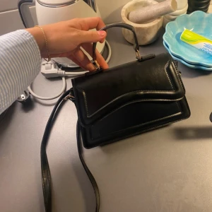 Svart handväska med vågig detalj - Snygg handväska perfekt till skolstart! Funkar både till utgång men även till vardags 