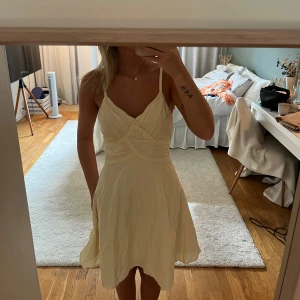 Ljusgul kort klänning med omlott och knyt - Supersöt ljusgul klänning. Saknar lappar så vet ej vart den kommer ifrån. I super fint skick men skulle behöva strykas💛💛