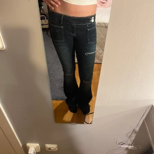 Mörkblå bootcut jeans Gina Tricot - Snygga mörkblå jeans från Gina Tricot med bootcut-modell och markerade sömmar. Jeansen har låg midja, klassiska fickor fram och bak samt stretchigt denimtyg som sitter riktigt bra. Perfekta för dig som gillar en retro vibe! Jag är 166 och är perfekt längd för mig. Jag ha aldrig använt dom här byxorna men lapparna är borta.💖