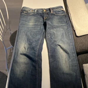 Blå Replay Rock Anne jeans, midwaist - Snygga blå jeans från Replay, modell Rock Anne, med klassisk femficksdesign och coola slitningar. Jeansen har midwaist-passform och raka ben. Materialet är slitstarkt denim i bomull. Perfekta för dig som gillar en tidlös och avslappnad look.