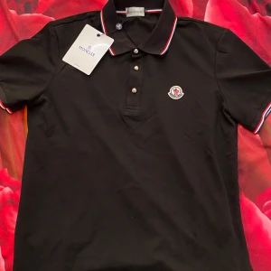 Svart pikétröja från Moncler - Svart pikétröja från Moncler. Den är helt ny med prislapp.