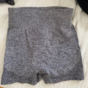 Grå högmidjade träningsshorts - Grå shorts med hög midja och tight passform. Materialet är stretchigt. Perfekta för gymmet. Snyggt mönstrad struktur på baksidan.