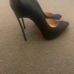 Svarta pumps med spetsig tå från Vesconte - Snygga svarta pumps från Vesconte med spetsig tå och hög klack. Skorna har en klassisk siluett och är tillverkade i slätt skinnmaterial. Perfekta för dig som gillar stilrena och eleganta skor med extra höjd.