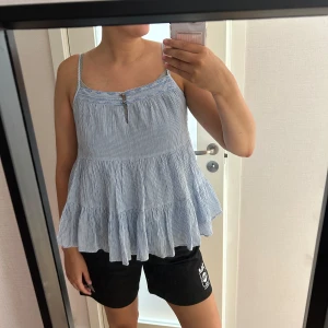 Randig blå volangtop  - Supersöt blå och vit randig topp.