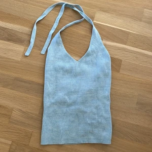 Ljusblå ribbad linnetopp från Bik Bok - Supersöt ljusblå ribbad linnetopp från Bik Bok i storlek S. Toppen har v-ringning, knytband i nacken och är ärmlös. Perfekt för varma dagar och enkel att styla med dina favoritjeans eller kjol. Materialet är mjukt och stretchigt för en skön passform.