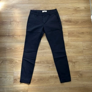 Kostymbyxor Mos Mosh - Svarta kostymbyxor från Mos Mosh. Knappt använda, så nästan som nya! Har två ganska djupa fickor i fram och två fakefickor i bak. Storlek: 36. Material: 50% bomull, 46% polyamid och 4% elastan. 