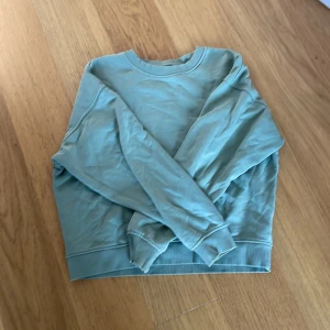 Ljusblå sweatshirt från Lindex XS - Snygg ljusblå sweatshirt från Lindex i storlek XS. Tröjan har rund hals, långa ärmar och ribbade muddar vid ärmslut och nederkant. Perfekt för chill dagar och enkel att matcha med jeans eller leggings. Materialet är mjukt och skönt bomull.