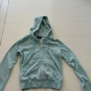 Juicy couture hoodie ljusblå - Blå juicy couture hoodie, använd en gång. Den är i helt bra skick, inga hål eller fläckar.