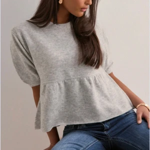 Ljus grå stickad topp - Säljer en ljusgrå stickad topp från Nelly, super fin och använd ett fåtal gånger.