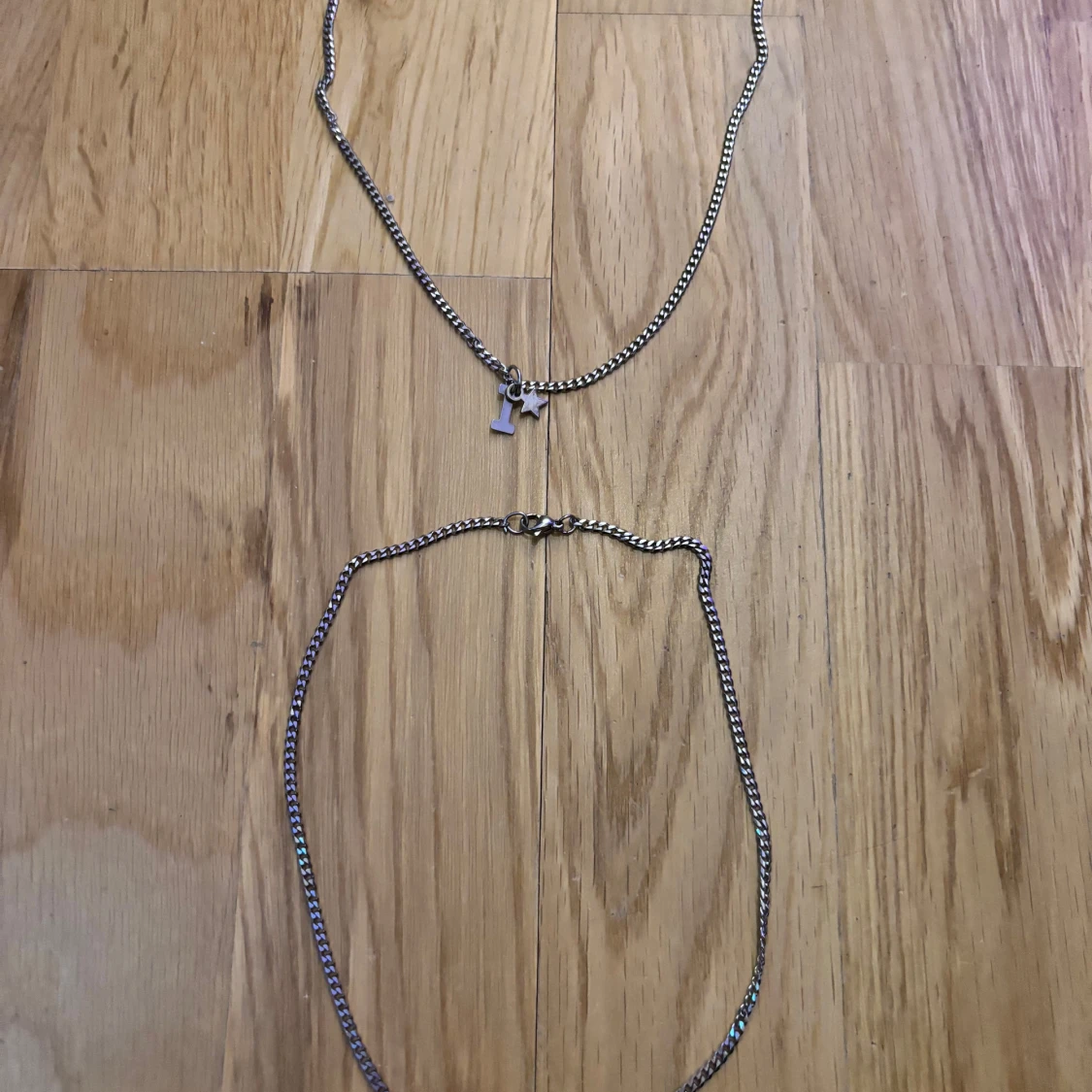 Två silverfärgade halsband med berlock