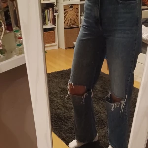 Ripped jeans - Säljer ett par blå jeans från Vero Moda med hål vid knäna. Modellen har raka ben och hög midja. Använda men fortfarande i fint skick💙🦋🪼 Storlek är 28/32. Jag är storlek s/m och de sitter ganska tajt på mig. Det är bara att skriva om man har frågor!😊💖