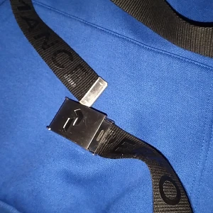 Svart peak performance bälte  - Säljer ett svart bälte i textil med ett stilrent metallspänne. Bältet har tryckt text längs bandet och spännet är i blank metall med en snygg detalj. Perfekt för att ge outfiten en sportig och modern touch.