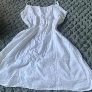 Vit sommarklänning med smala axelband - Säljer en luftig vit klänning med smala axelband. Klänningen är ärmlös och är perfekt för varma dagar. Tunt och mjukt material.
