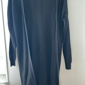 Svart lång cardigan jacka från Esmara - Säljer en svart lång cardigan jacka från Esmara i storlek XS/S.  Koftan är stickad och har lång ärm, perfekt för lager-på-lager och en stilren look. Enkel att matcha med olika outfits.
