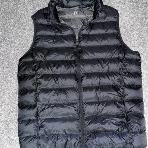 Svart dunväst från Uniqlo Ultra Light Down - Säljer en svart dunväst från Uniqlo Ultra Light Down. Västen är lätt, har dragkedja framtill och quiltad design. Perfekt för lager-på-lager och enkel att packa ner i medföljande påse. Den är knappt använd nästan helt ny köpt. Pris kan självklart diskuteras 🤩